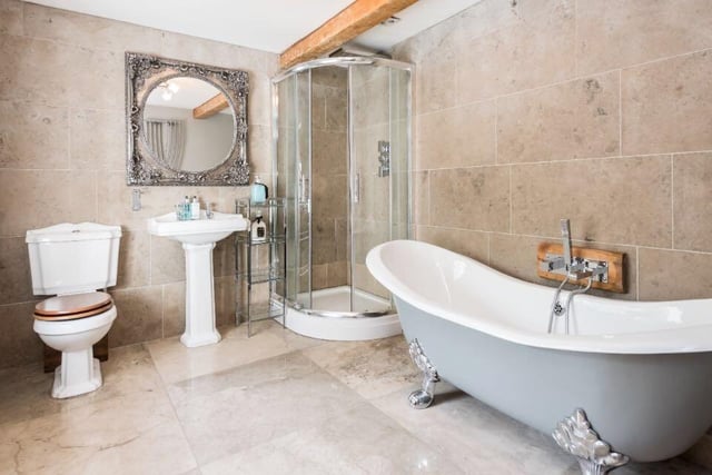 There are four bathrooms throughout the property, with this marble suite featuring a toilet, sink, walk-in shower and free-standing bath tub.