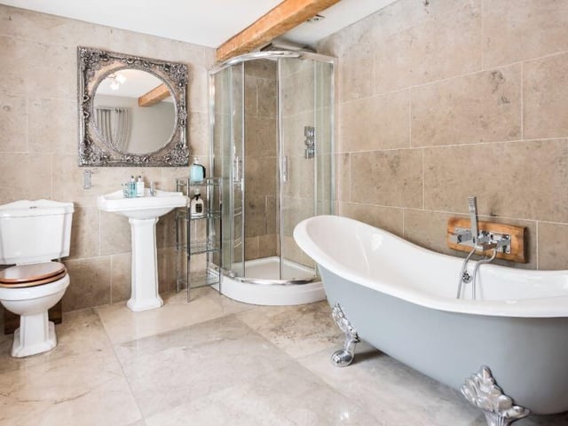 There are four bathrooms throughout the property, with this marble suite featuring a toilet, sink, walk-in shower and free-standing bath tub.