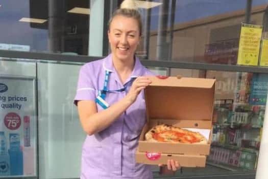 A staff member from the coronary care unit at the Northern General Hospital collecting their pizza. Picture: Proove.