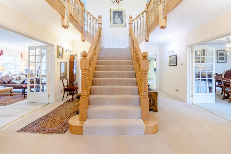 A welcoming reception hall with a striking oak staircase.