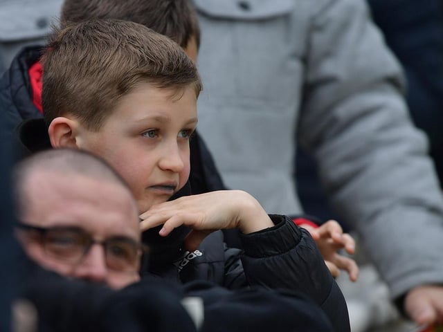 A young supporter watches the action unfold.