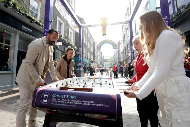 LONDON, ENGLAND - MARCH 28:In this handout image Rio Ferdinand, Fara Williams , Liv Cooke and Elz the Witch play table football featuring female figurines on London’s iconic Carnaby Street to mark tickets going on sale for UEFA Women’s EURO England 2022 on March 28, 2022 in London, England. (Photo by John Phillips/Handout via Getty Images)