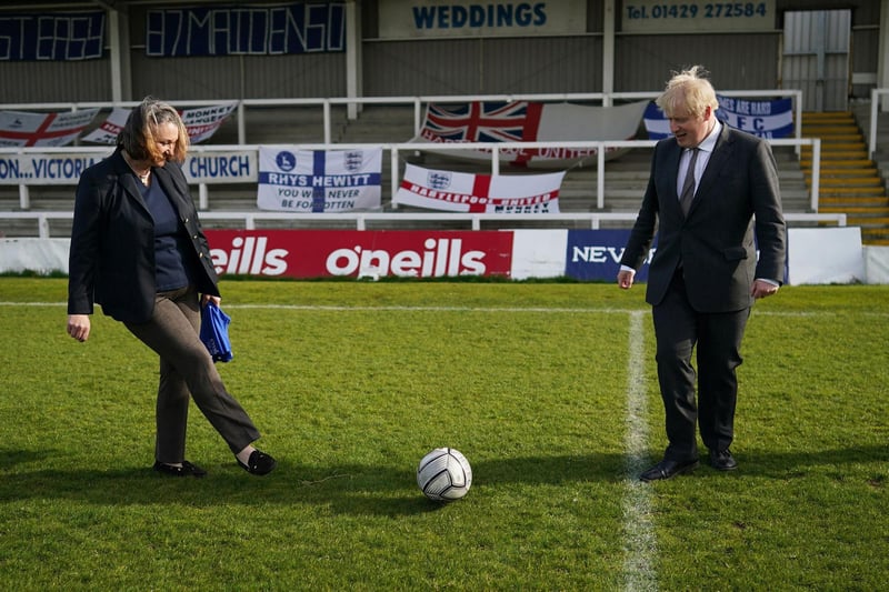 Conservative Party candidate Jill Mortimer (L) passes the ball to Britain's Prime Minister Boris Johnson (R) on a visit to Hartlepool United Football Club as he campaigns in Hartlepool, north-east England on April 23, 2021, ahead of the 2021 Hartlepool by-election to be held on May 6.