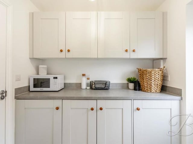 Just off the kitchen/diner is this useful utility room. It boasts a range of modern, matching units and cabinets, with work surface over. A door leads to the back garden.