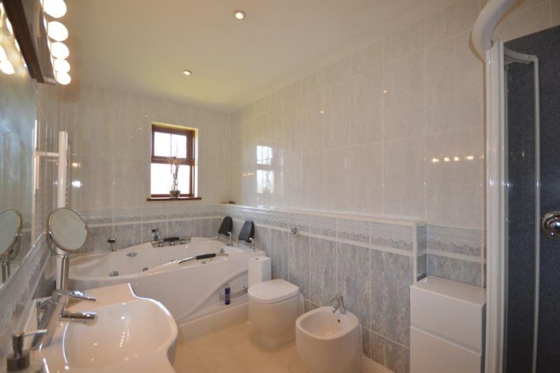 A large en-suite with a back to wall double width jacuzzi bath and separate shower.