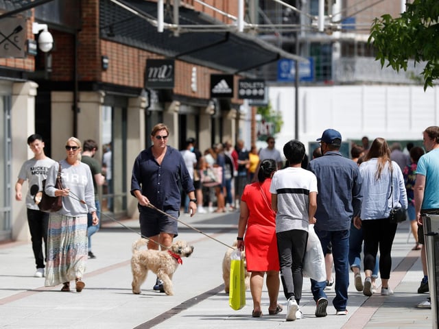 Shoppers walk past recently re-opened shops at Gunwharf Quays shopping centre in Portsmouth