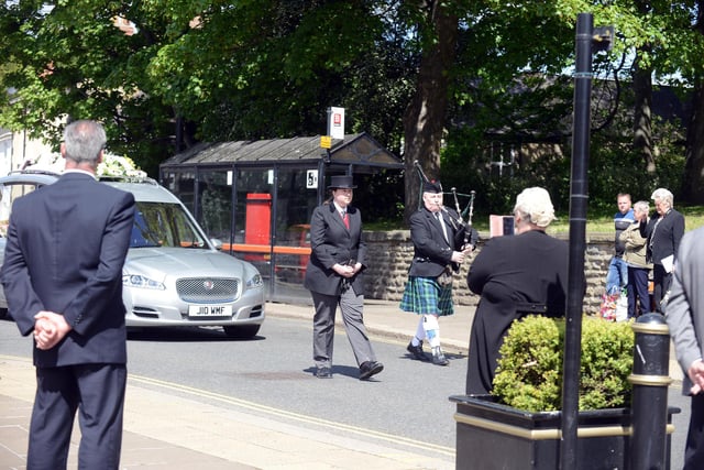 A lone piper performed Amazing Grace as the funeral car pulled up outside the church.