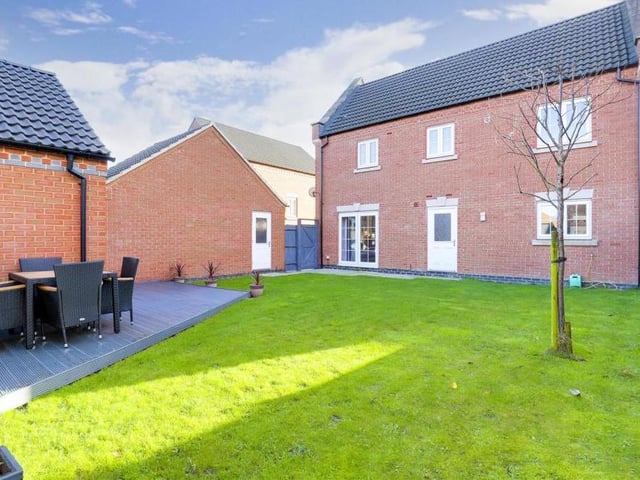 Moving outside now, and this is a view from the rear of the Sutton property, showing a private, enclosed garden, with a lawn, a pleasant patio area and a decked seating area.
