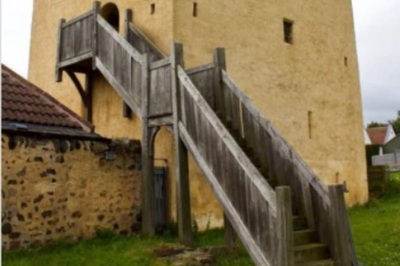 The tower is accessed via an exterior wooden staircase.