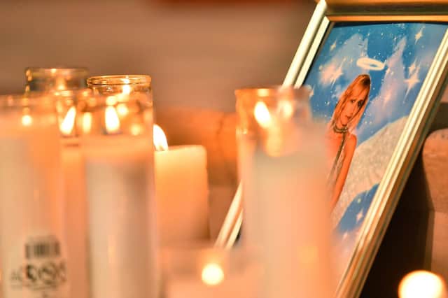 Candles are placed in front of a photo of cinematographer Halyna Hutchins during a vigil in her honour