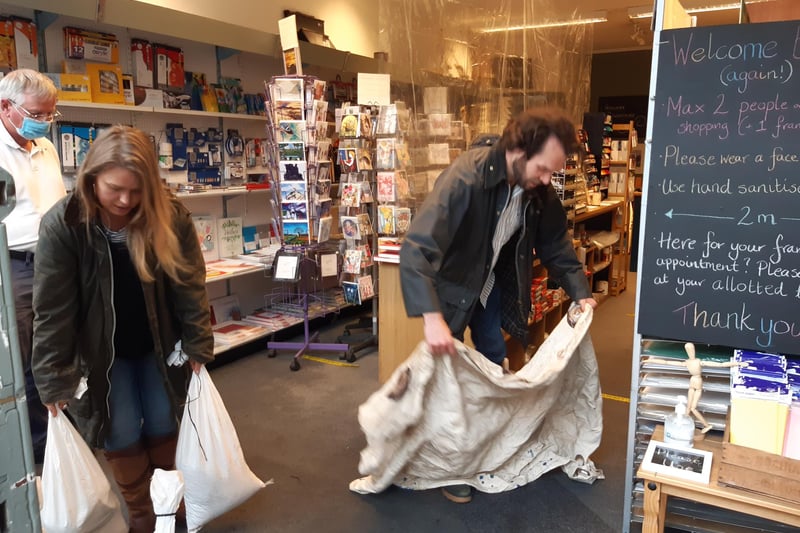 Tom and Lauren Holmes, owners of Henderson Art Shop on Raeburn Place, clean up after today's flood. Stockbridge was badly hit by the extreme downpour which caused several shops in the area to close temporarily.