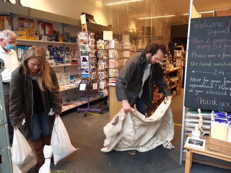 Tom and Lauren Holmes, owners of Henderson Art Shop on Raeburn Place, clean up after today's flood. Stockbridge was badly hit by the extreme downpour which caused several shops in the area to close temporarily.