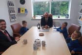 Rother Valley MP Alex Stafford (pictured left) sitting with pupils at St Joseph's School and the executive headteacher Andrew Truby