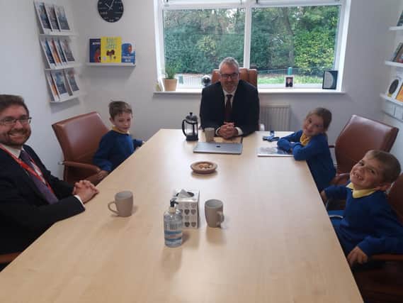 Rother Valley MP Alex Stafford (pictured left) sitting with pupils at St Joseph's School and the executive headteacher Andrew Truby
