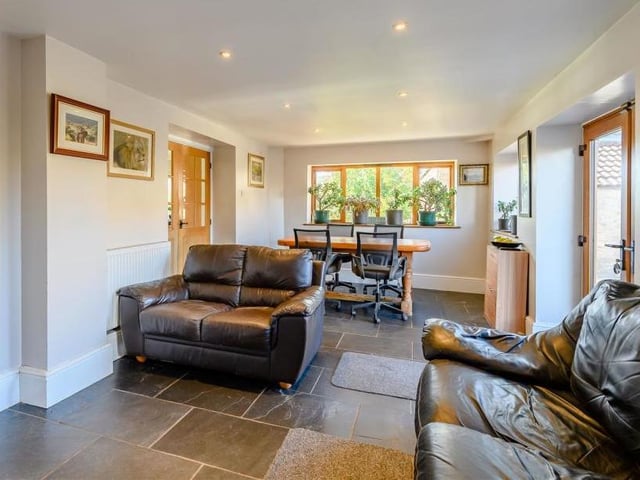 The kitchen/breakfast room leads to this garden room, which is one of many dual-aspect rooms in the farmhouse. Spacious, it has a tiled floor, eight ceiling-spotlights and three double-glazed windows to the side and back.