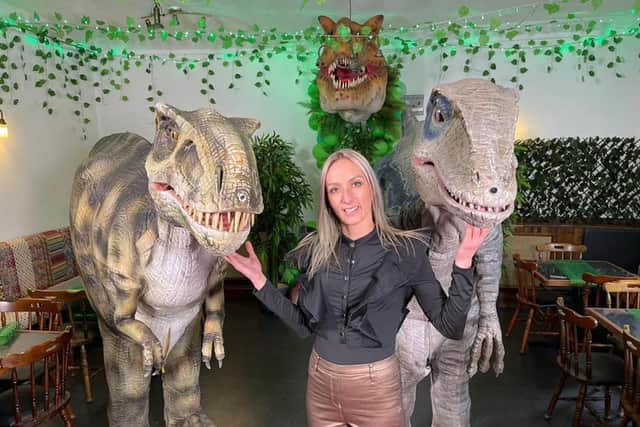Jurassica owner Chantelle Synyer with the two animatronic dinosaurs Tricksy the T-Rex and Bluey the Velociraptor at the dinosaur-themed pub in Ecclesfield, Sheffield