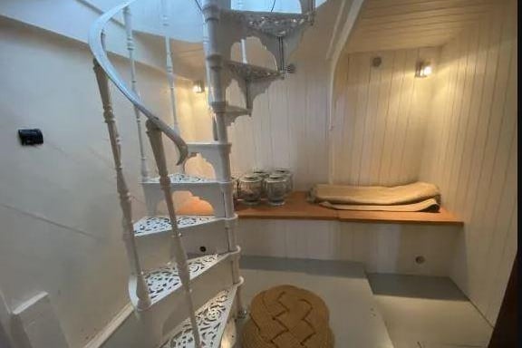 There is a spiral staircase inside the house boat.