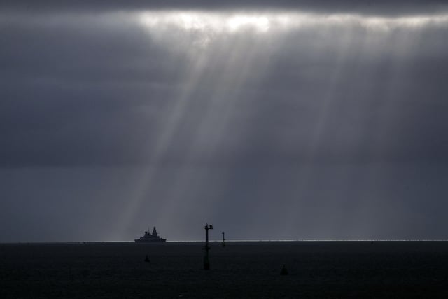 Sun pierces the clouds as HMS Dragon appears on the horizon