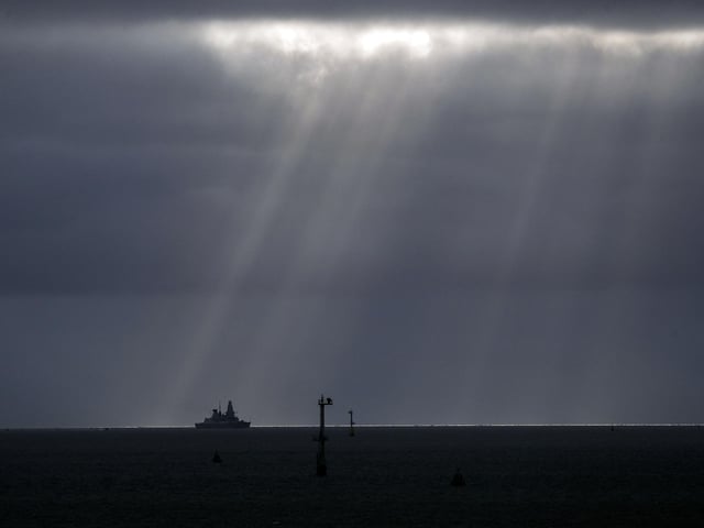 Sun pierces the clouds as HMS Dragon appears on the horizon
