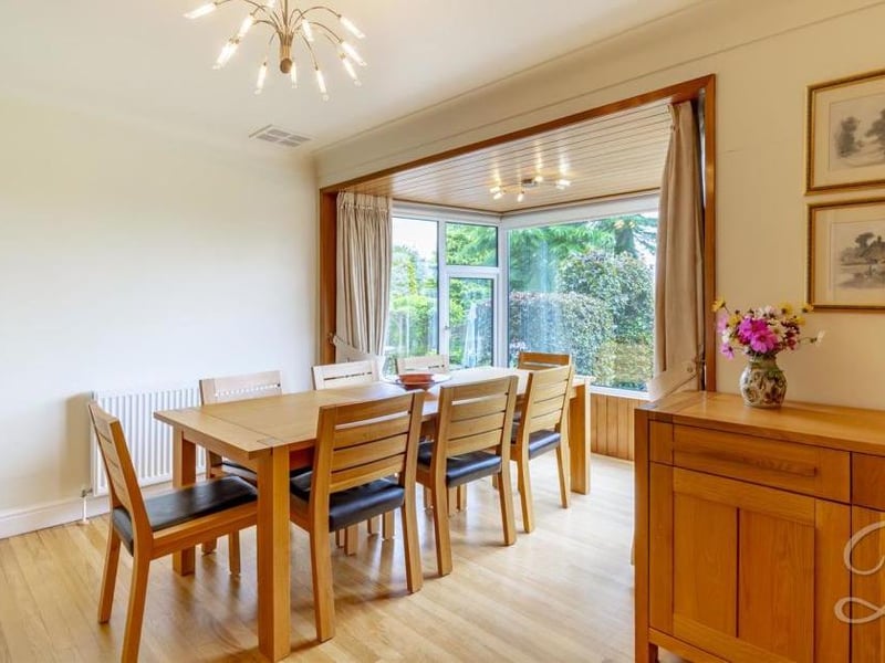A pleasant dining area in front of big, bright bay windows overlooking the back garden. It has a central-heating radiator.