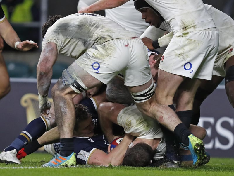 Scotland's Duhan van der Merwe, lower left, rolls over the line to score a try during the Six Nations rugby union international between England and Scotland at Twickenham stadium