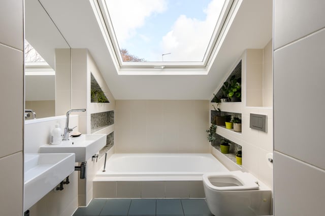 Four of the bedrooms have their own private en-suite, with this modern room boasting an impressive sunken bathtub, twin sinks and a wc, plus modern tiling and a skylight window over the tub.
