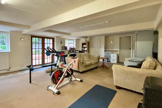The main part of the annexe is this sizeable and versatile room, which could be used for a variety of things, maybe as a games room. Currently it is a gym, but it has double doors leading into the garden, and also built-in storage.