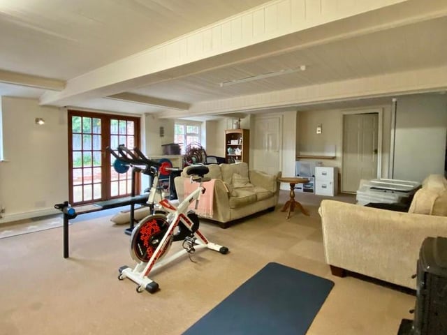 The main part of the annexe is this sizeable and versatile room, which could be used for a variety of things, maybe as a games room. Currently it is a gym, but it has double doors leading into the garden, and also built-in storage.