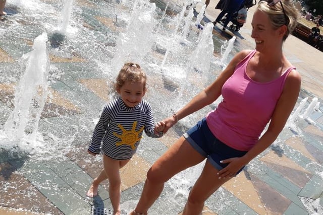 Mum and daughter take advantage of the fountains in the Peace Gardens together