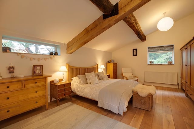 The spacious main bedroom has side facing timber double glazed windows and a rear facing double glazed panel. It also boasts exposed wooden beams, pendant light points and timber flooring.