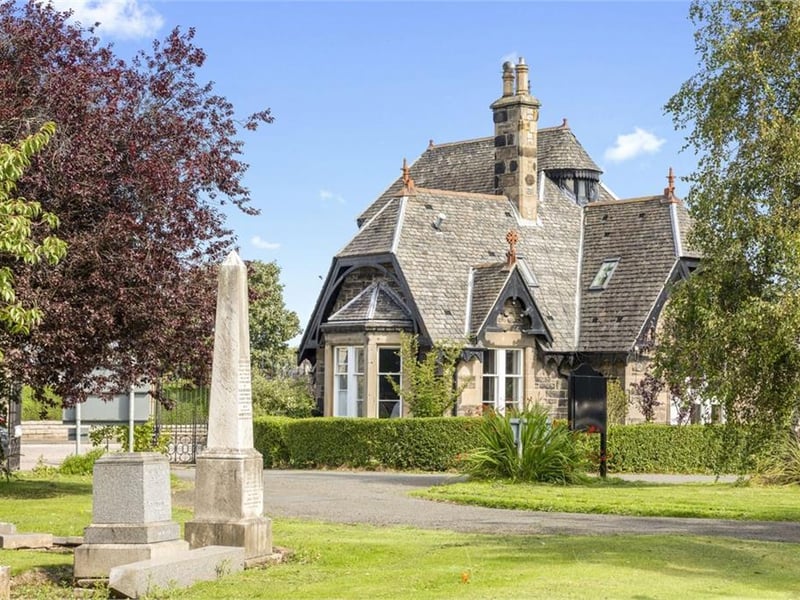 The property has a unique location at the entrance to the cemetery.