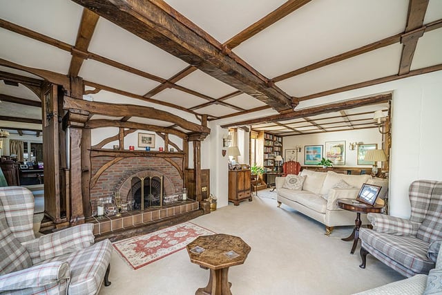 The living room boasts an impressive feature fireplace at its heart, with plenty of room for seating and doors leading out to the inner courtyard.