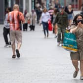 A woman sanitizes her hands as she walks through the city centre of Leicester - Joe Giddens/PA Wire