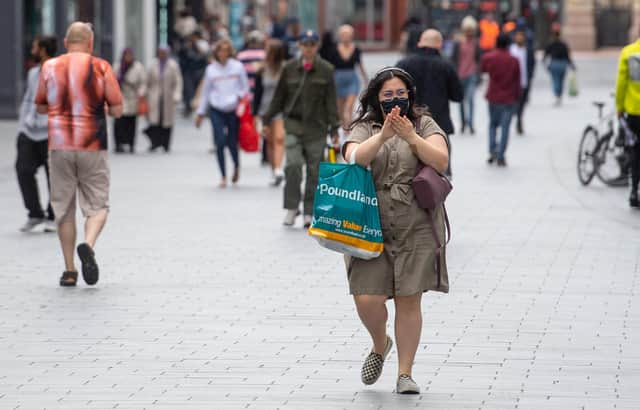 A woman sanitizes her hands as she walks through the city centre of Leicester - Joe Giddens/PA Wire