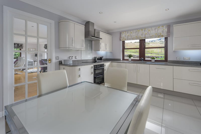 The stunning kitchen offers a very good number of stylish high gloss white wall and base units.