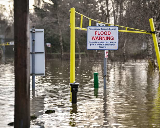 A flood warning sign at the entrance to a flooded car park beside Tewkesbury Abbey, where flood watches are in place with more wet weather expected in the coming days.