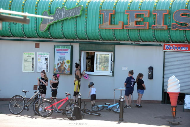 People can be seen queuing for ice cream as a way to cool off.
