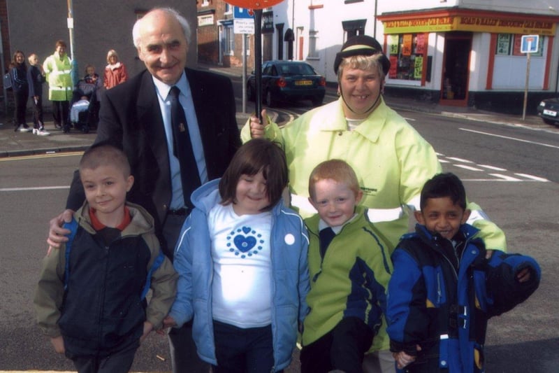 Henry Bradley Infant school istudents Daniel Hibbert (8) Katrina Boyce (6) Richard Robinson (6) and Gobi Sivalingham (7) show councillor Walter Burrows and school crissing patrol Diane Frost just how good they are at walking at school in 2003