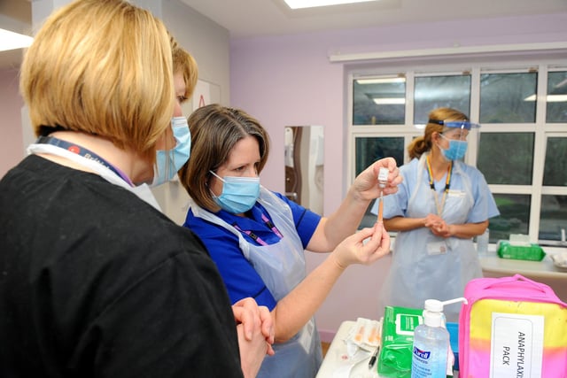 Someone will prepare your vaccination like (middle) Nurse Teresa Ellis is doing here. Picture: Sarah Standing (010221-2014)