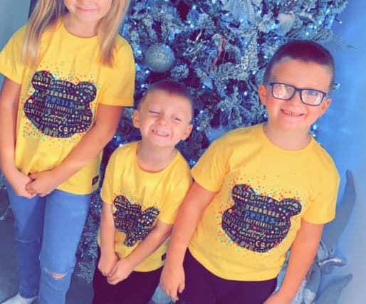 Bethanie Mae Grayson's children, Lacey aged eight, Freddie age six and Hawley age four, stood and proudly posed for a photo in front of their Christmas tree.