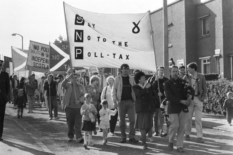 A piper leads the marchers holding anti-poll tax banners ('SNP Say No to the Poll-Tax) during a demonstration at Sighthill in Edinburgh, October 1989.