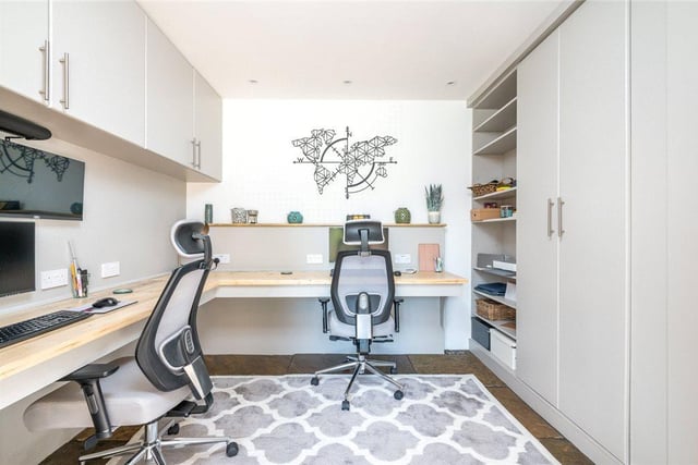 The well-appointed home office is equipped with a wealth of storage space and enough room for two desks.