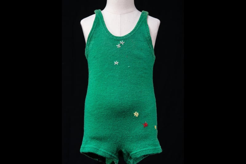 This swimsuit belonged to Mabel Macaulay who grew up on Kirkibost Island off the south west coast of North Uist. It was made by her mother or aunt on a machine, like many of her clothes, and repaired by hand with holes stitched together with little embroidered flowers.