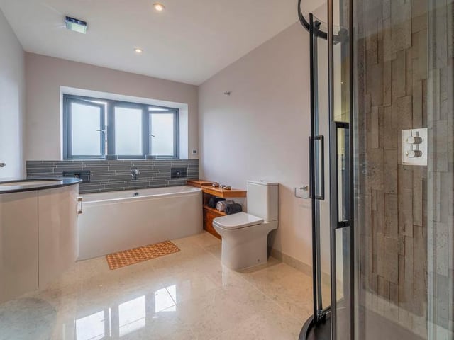 The en suite to the master bedroom. Slick and classy, with bath, WC and separate shower.