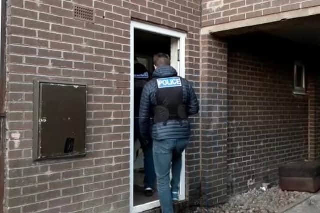 Police entering the property in Whiston, Rotherham through a front door that had been left open by a suspect