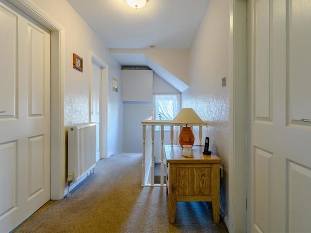 At the top of the stairs, we are greeted by this landing, which links all four bedrooms. It features a hatch leading to a partially boarded loft.