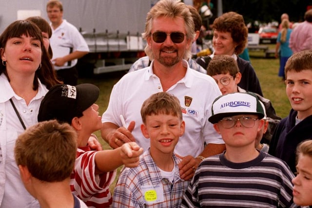 Noel Edmunds waiting with young children about to go on a helicopter ride in 1996
