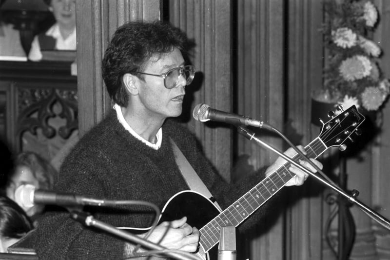 Singer Cliff Richard playing the guitar and singing in St Paul's church Edinburgh, November 1985.