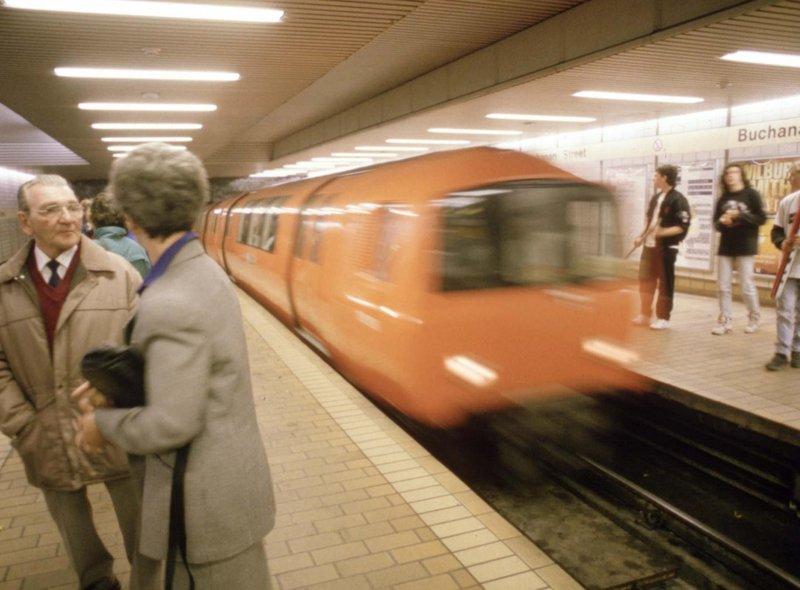 A couple chatting in Buchanan Street underground station in Glasgow as the train comes in, August 1990.