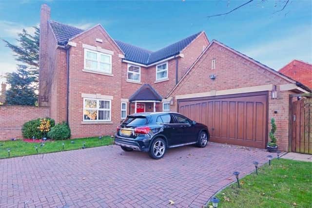The detached, four-bedroom house on Springwood Drive, Mansfield Woodhouse which is "realistically priced" at £500,000, says the Express Estate Agency. This is the front, which includes a brick-laid driveway leading to a double garage, as well as a lawn with mature shrubs and trees.